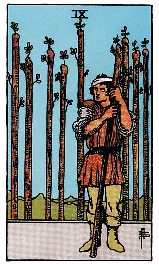 9 of Wands tarot card from the Rider–Waite deck, depicting a wary, bandaged figure clutching one wand while eight stand behind